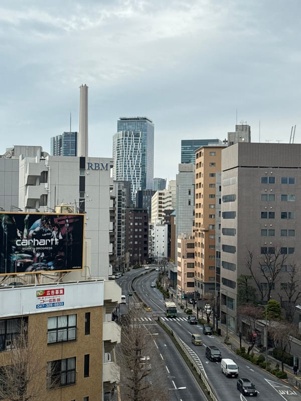 Commercial jet flies over bustling Shibuya under overcast morning sky
