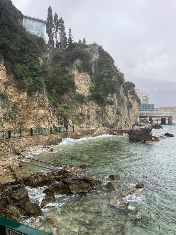 Tourist explores Budva's coastal landmarks during overcast afternoon