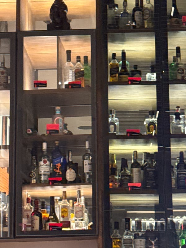 Illuminated liquor display case observed at bar location