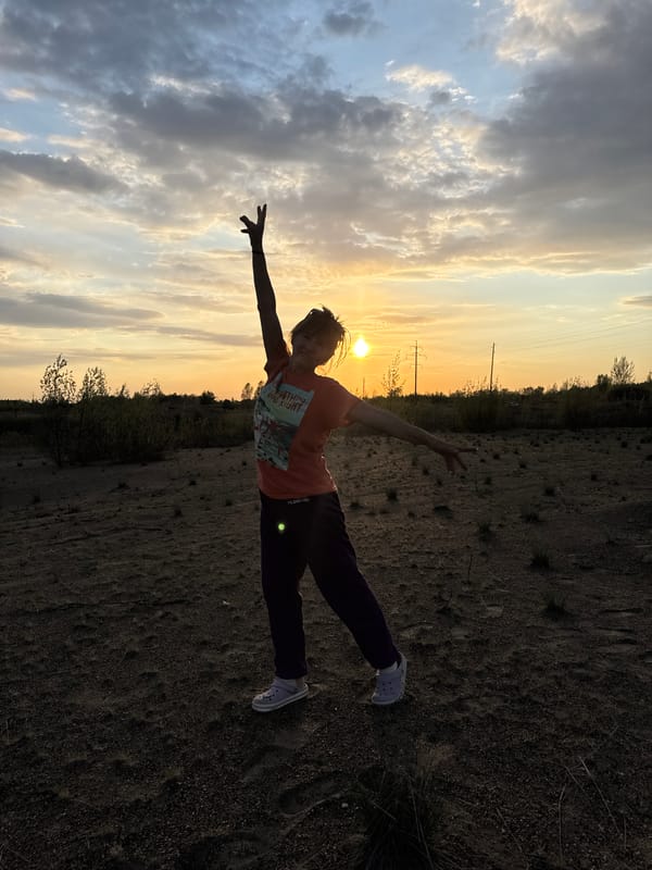 Woman strikes playful poses in Russian field at sunset