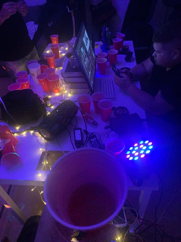 Cluttered desk with red cups and electronics documented