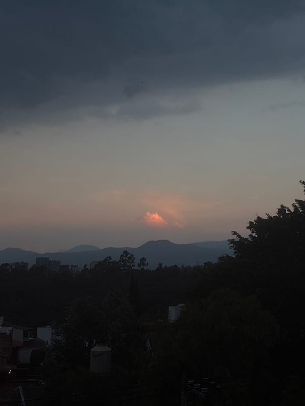 Dusk skyline captured over Mexico City showing distant hills
