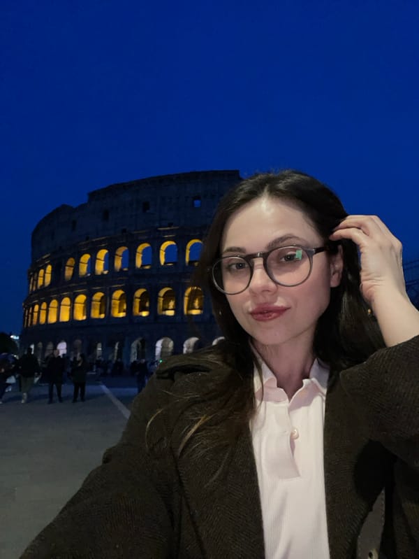 Tourist takes nighttime selfie at illuminated Colosseum in Rome