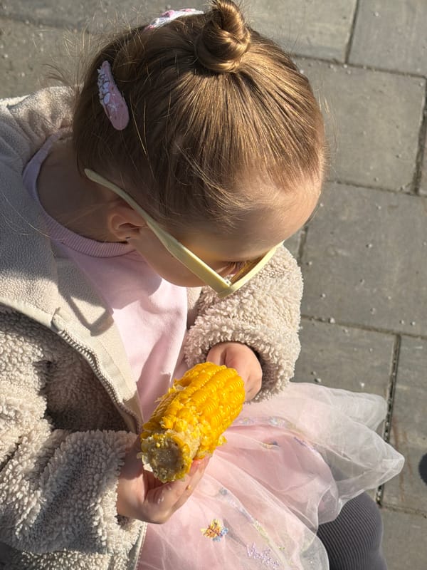 Child enjoys corn snack on Moscow bench