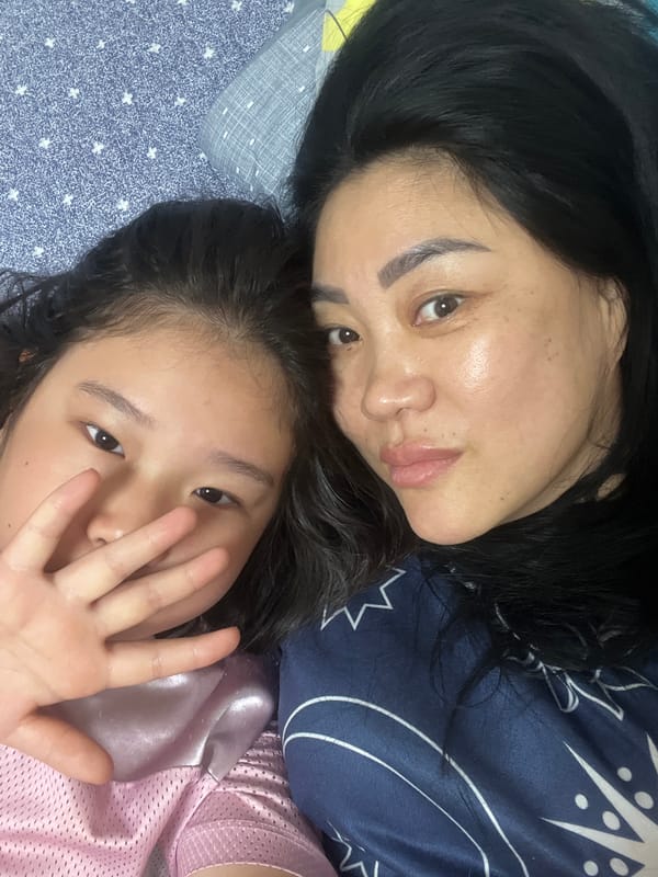 Woman and girl share playful moment on patterned bed
