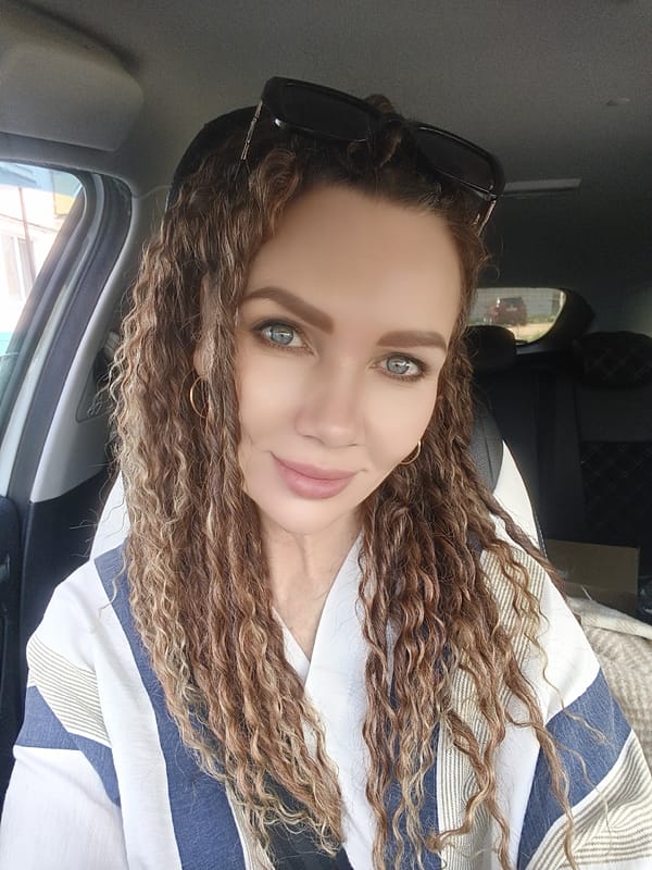 Woman with curly hair spotted in car wearing striped shirt