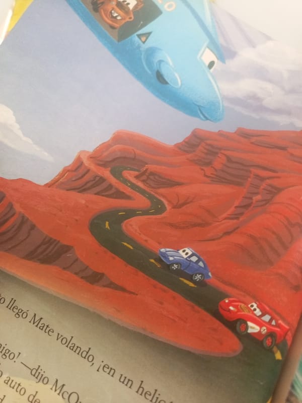 Spanish kids' books featuring Pixar characters, flipped through in Venezuela