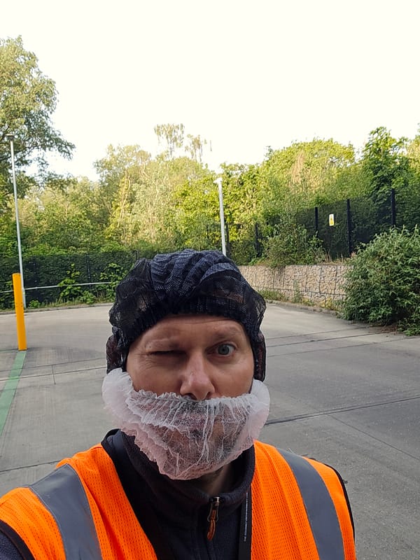 Safety-clad worker spotted winking in London industrial area