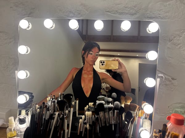 Woman applies theatrical red makeup at Paris vanity station