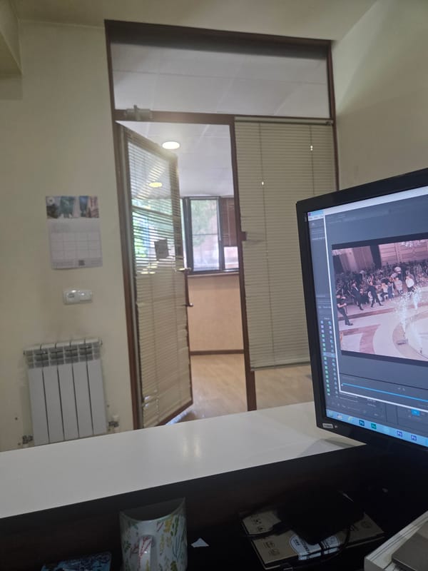 Adobe-themed clock and editing setup in an Armenian workspace