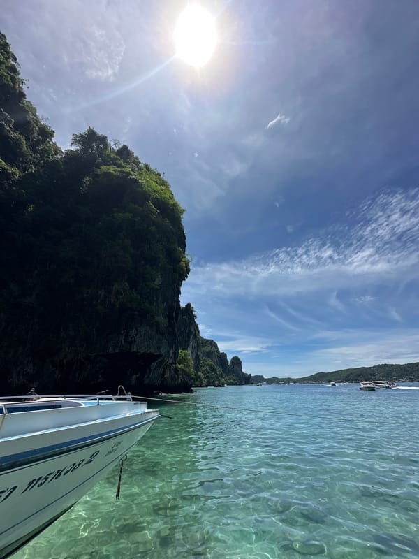 On the water at Haad Hin Khom's rocky coastline