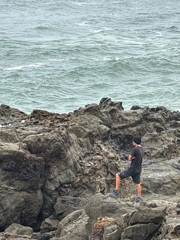 Man explores rocky coastline cliffs in Arica, Chile