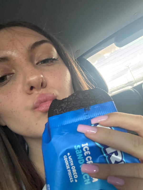 Person enjoys Oreo ice cream sandwich in car, Sofia