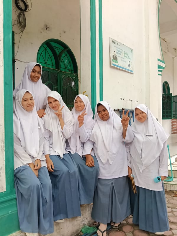 Students pose, construction work continues in Lhokseumawe, Indonesia