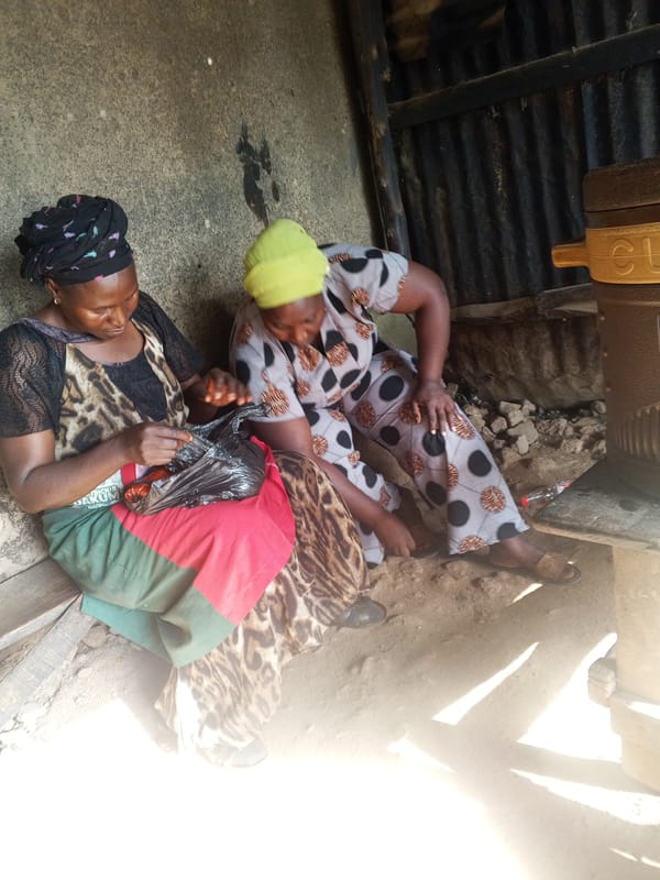 Women prepare food in outdoor market setting