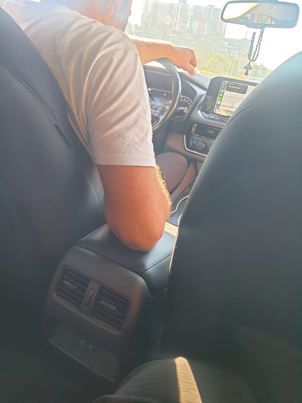 Inside a moving car, city traffic rolling by