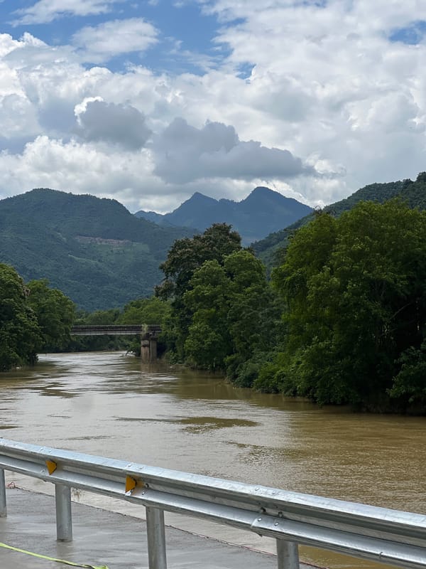 Swollen brown river cuts through misty mountains in northern Vietnam