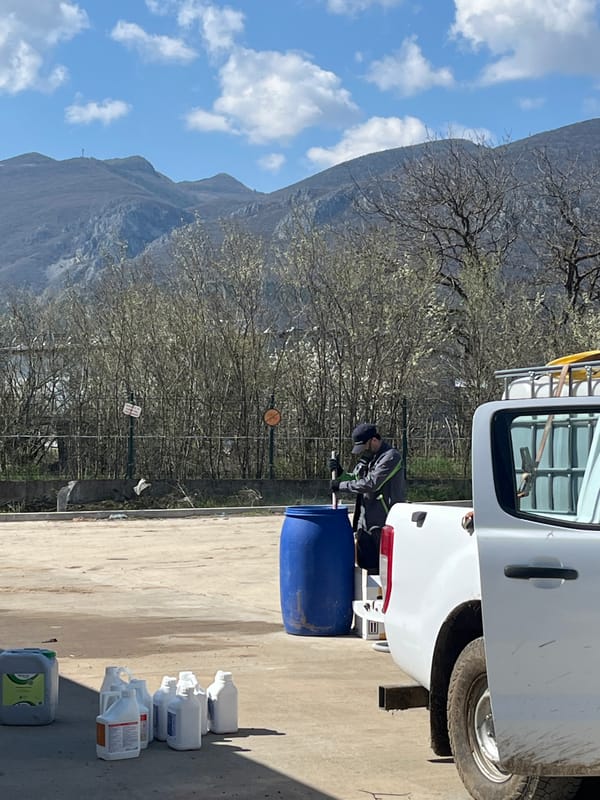 Worker transfers liquid from barrel to containers in Vratsa
