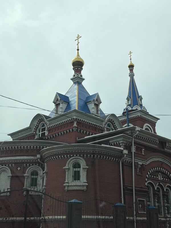 Twin-domed brick building photographed in Осеченки, Russia