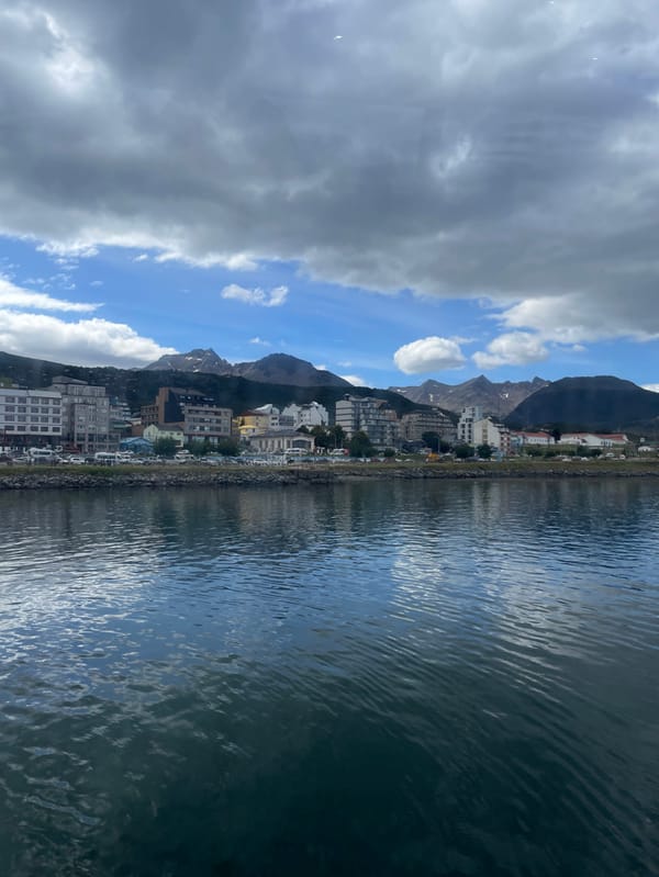 Cruise ships dock at Ushuaia harbor amid mountain backdrop