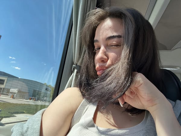 Woman winks while holding hair inside vehicle in Pancharevo