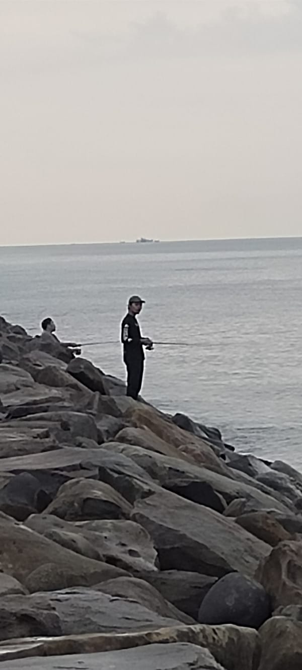 Fishing and coastal life along Lhokseumawe's rocky shoreline