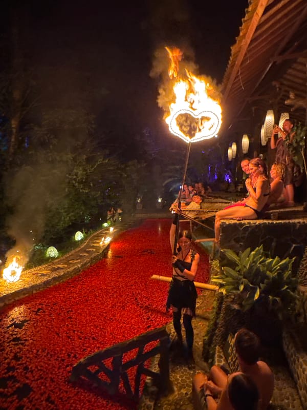 Nighttime fire spinning performance at an outdoor venue in Blahbatuh