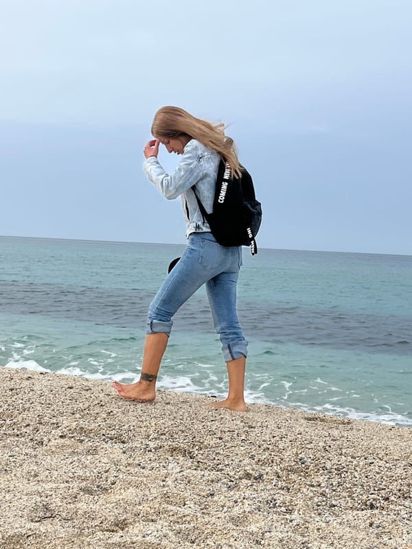 Woman stands barefoot on beach in Alanya, Turkey