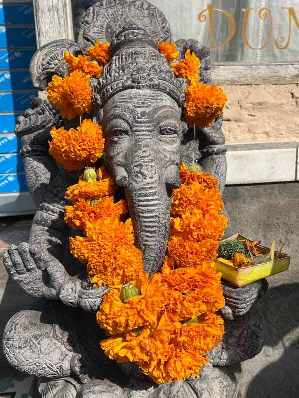 Tourist photographs ornate Balinese temple architecture in Ubud