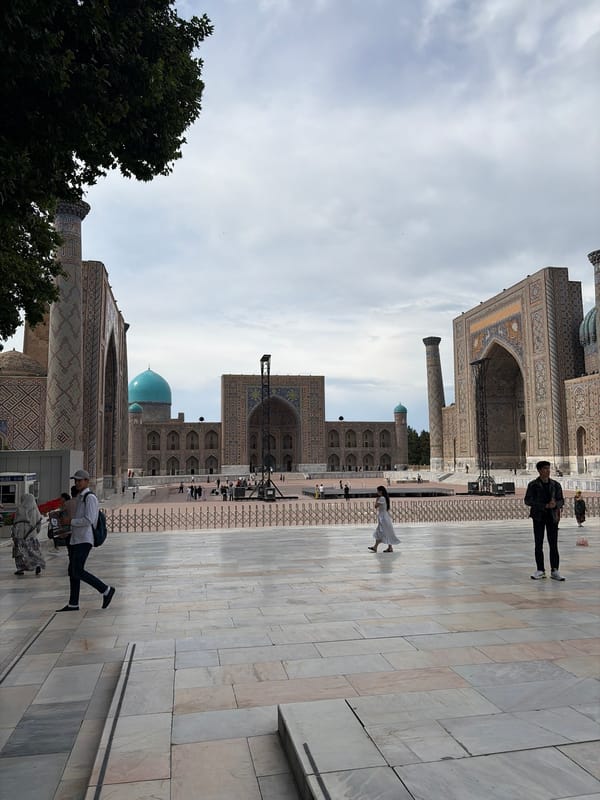 Tourist documents Samarkand's Registan Square architectural complex under overcast skies