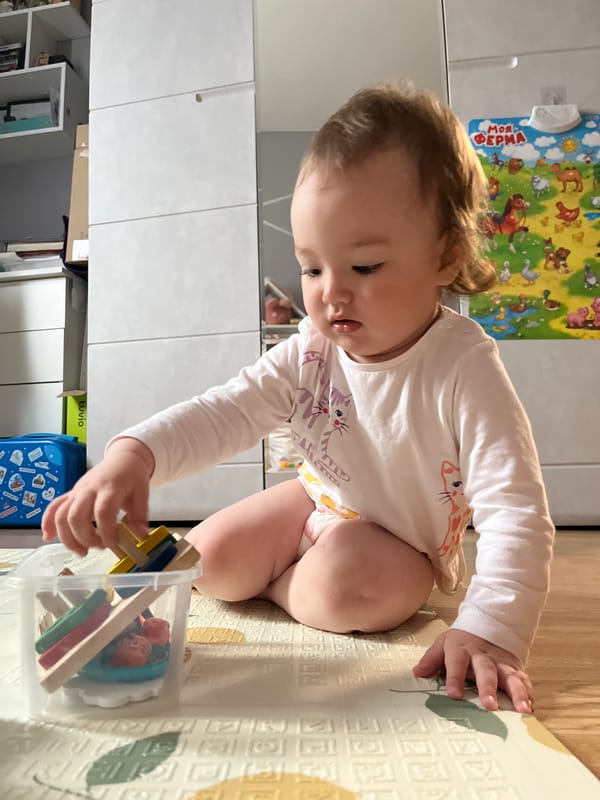 Baby plays with toys on mat in Shushary home