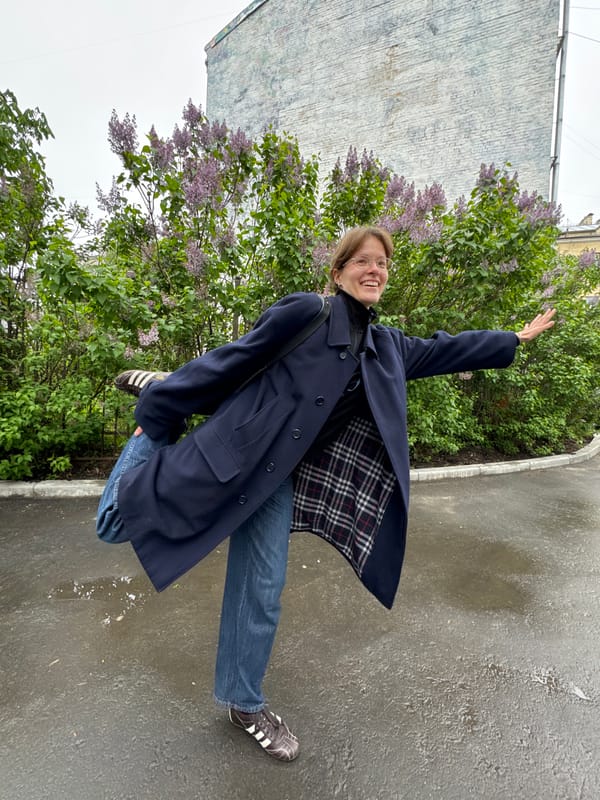 Woman photographs spring lilacs on rainy Moscow streets