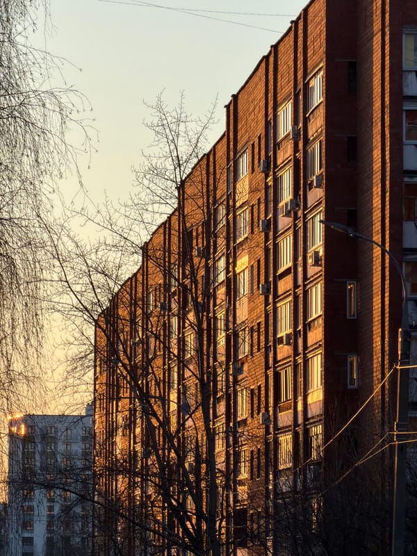 Residential buildings and moon captured in Izhevsk afternoon