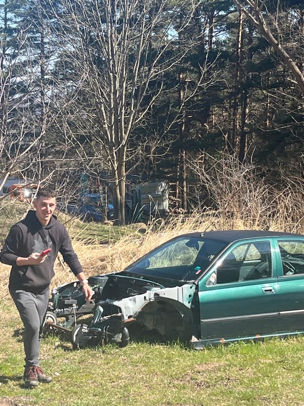 Dismantled car documented in rural Bulgarian village setting