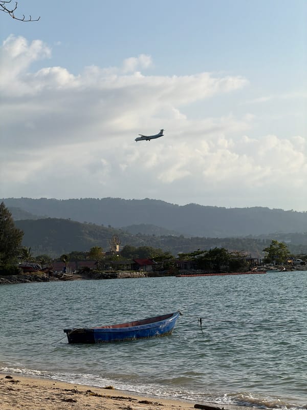 Plane descends over Ko Samui as beach life carries on below