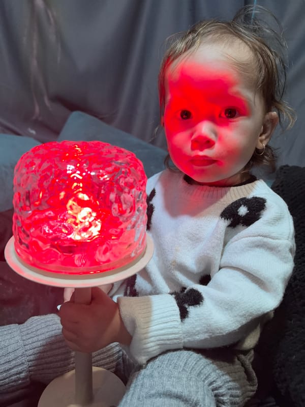 Child plays with colorful lamps in Noviy, Russia