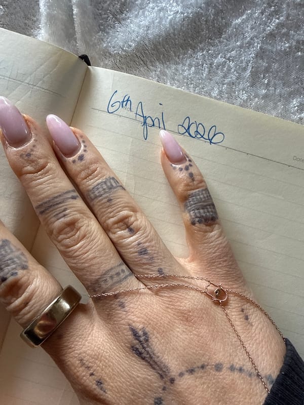 Tattooed hand photographed resting on notebook in Strömstad