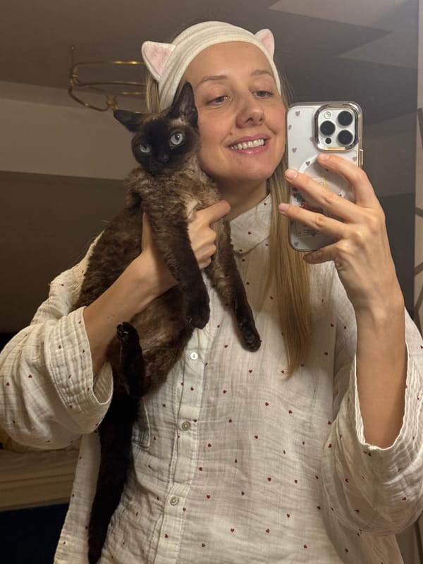 Woman takes selfies with cat wearing matching cat ears