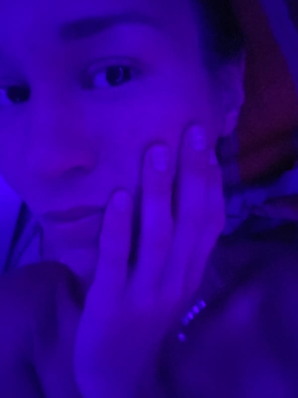 Person and ornate fabrics photographed under blue lighting in Thailand