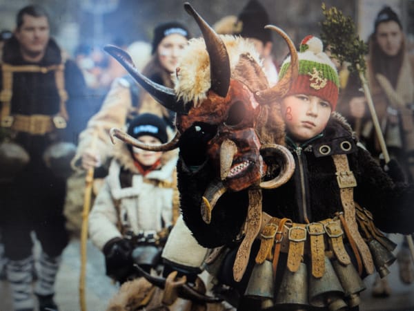 Traditional festival with costumed participants and wooden cannon display
