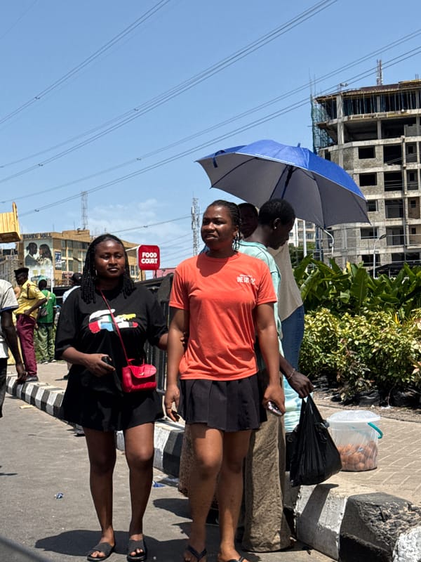 Four people gather on sidewalk in Ilado, Nigeria