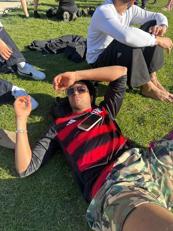 Person enjoys pink popsicle near neon signage in Paris