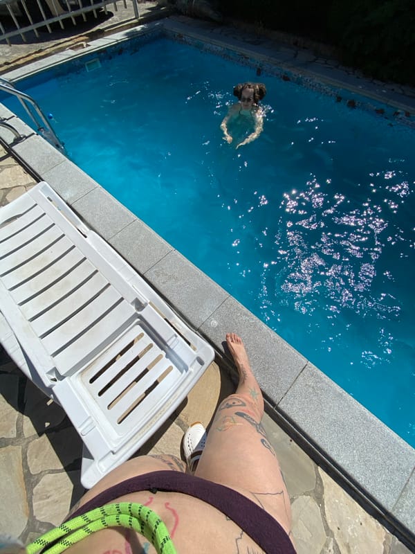 Poolside summer day in Mtskheta, tattoos, loquats, and a sleepy dog