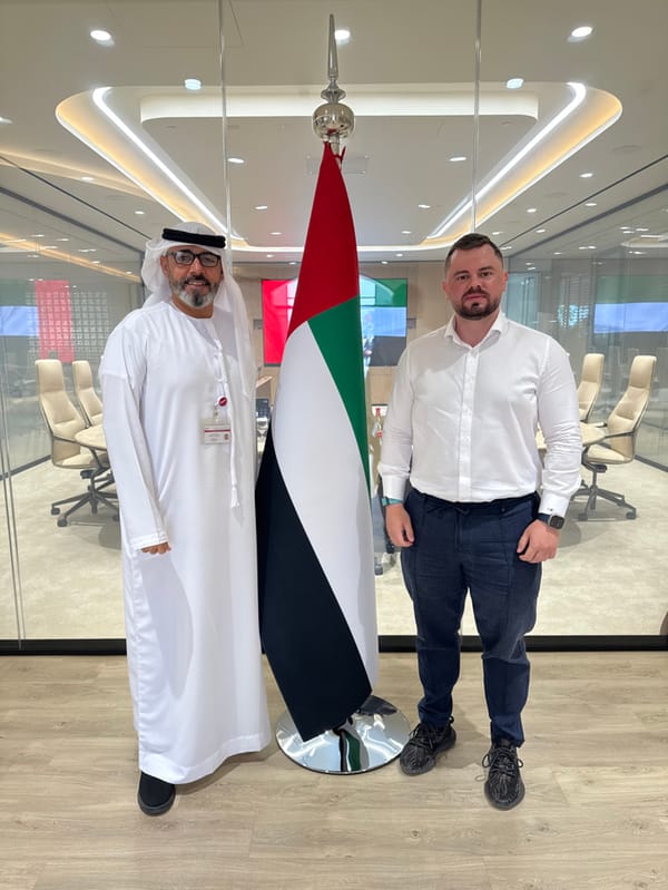 Men pose with UAE flag near Dubai Knowledge College
