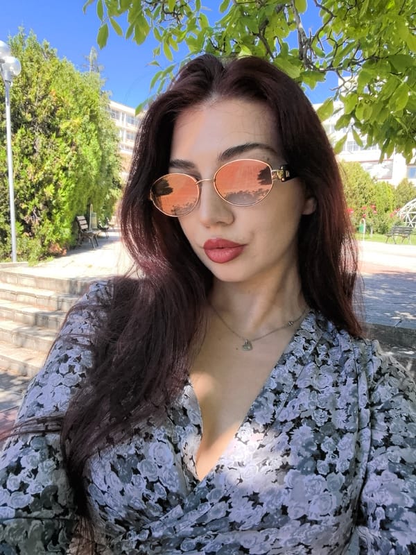 Woman photographs herself in university garden among blooming roses