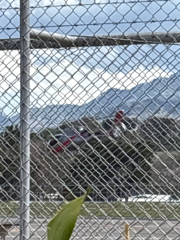 Green helicopter lands at San José helipad with door open
