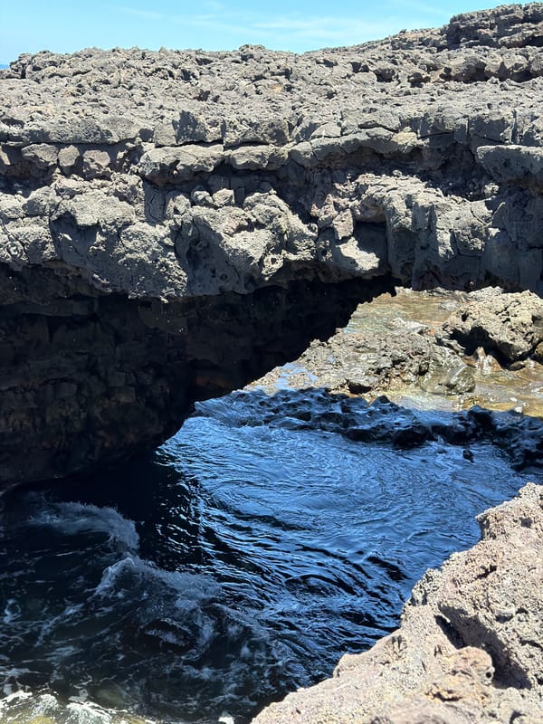 Ocean waves crash against volcanic rocks in Tinajo, Spain