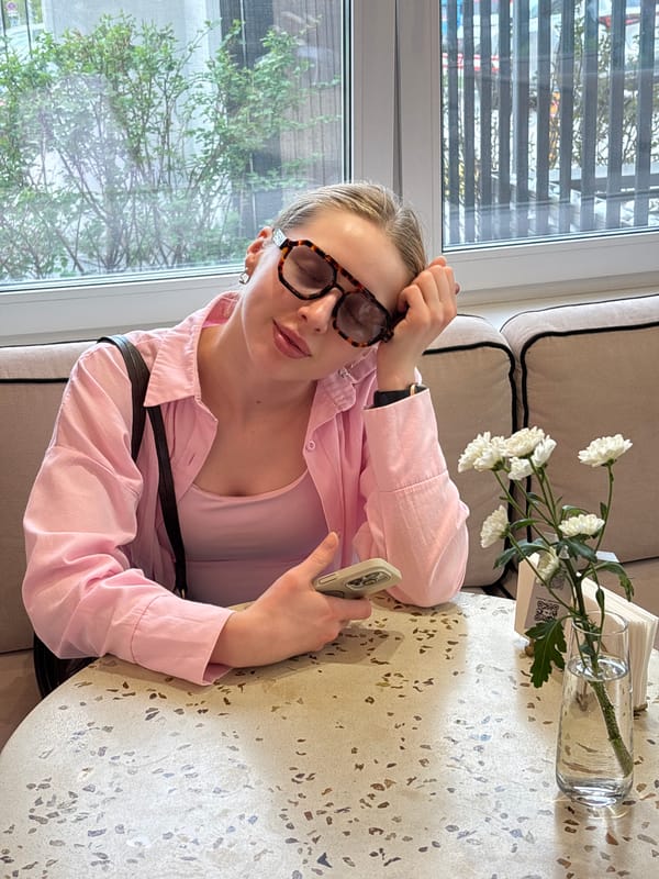 Woman uses phone at pastry cafe in Perm