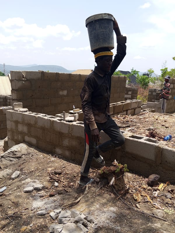 Construction workers build concrete walls in Lokoja, Nigeria