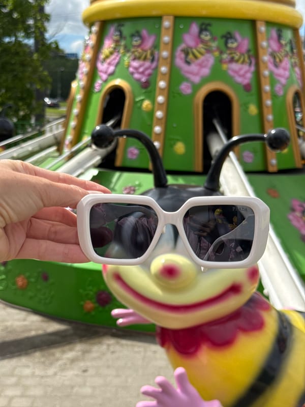 Woman poses with Prada sunglasses at Saint Petersburg amusement park